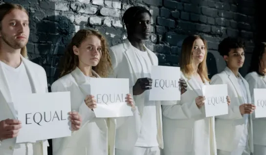 Many people holding a sign that says Equal