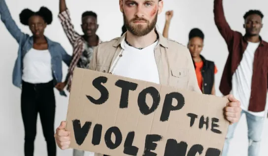 Man holding a sign saying Stop the violence