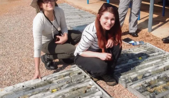 Two people crouching by sediment cores