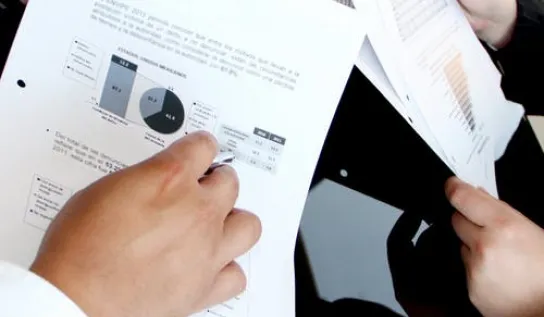 Someone holding business papers with graphs on it