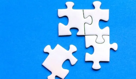Four white puzzle pieces on a blue background, with three put together.