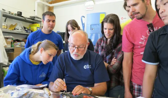 Students standing around a professor 