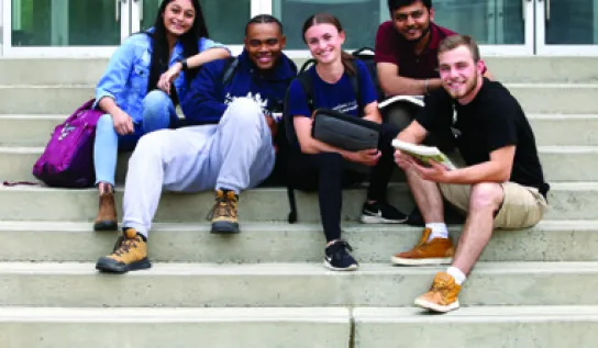 Laurentian University students sitting on the steps to the R.D. Parker Building.