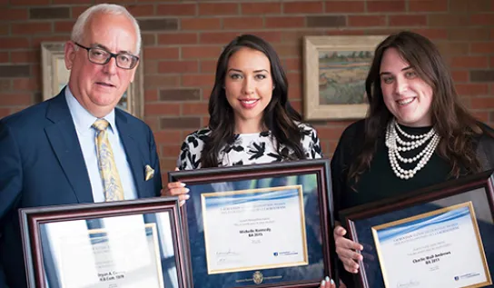 A group of individuals posing for a photo while holding degree frames