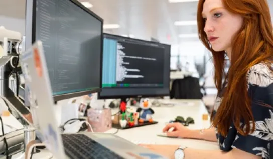 A student working on her computer at a desk 