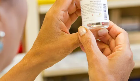 A student holding a glass vial