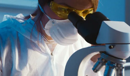 A student looking at a specimen through a microscope
