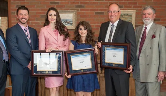 Grads holding diploma frames