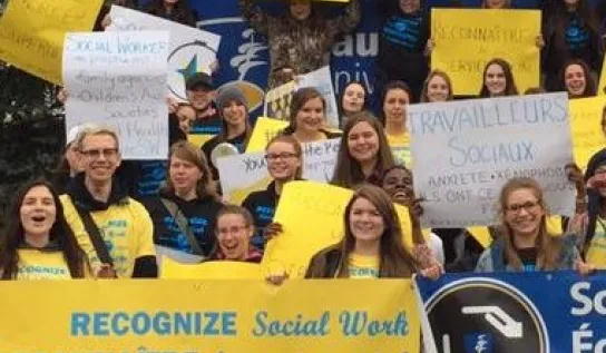 Social Work students holding posters and posing for a photo together.