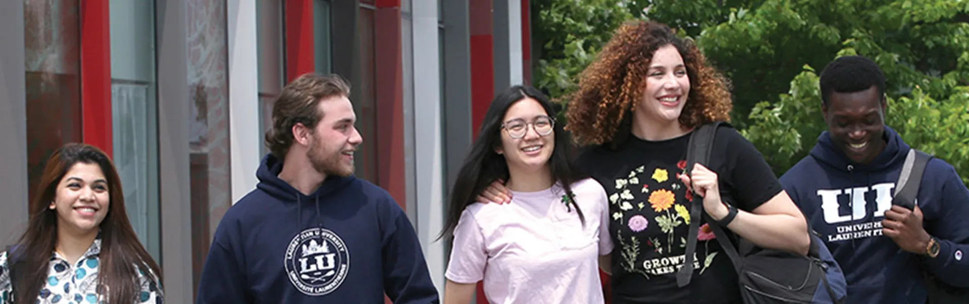 5 students walking outside of the student center