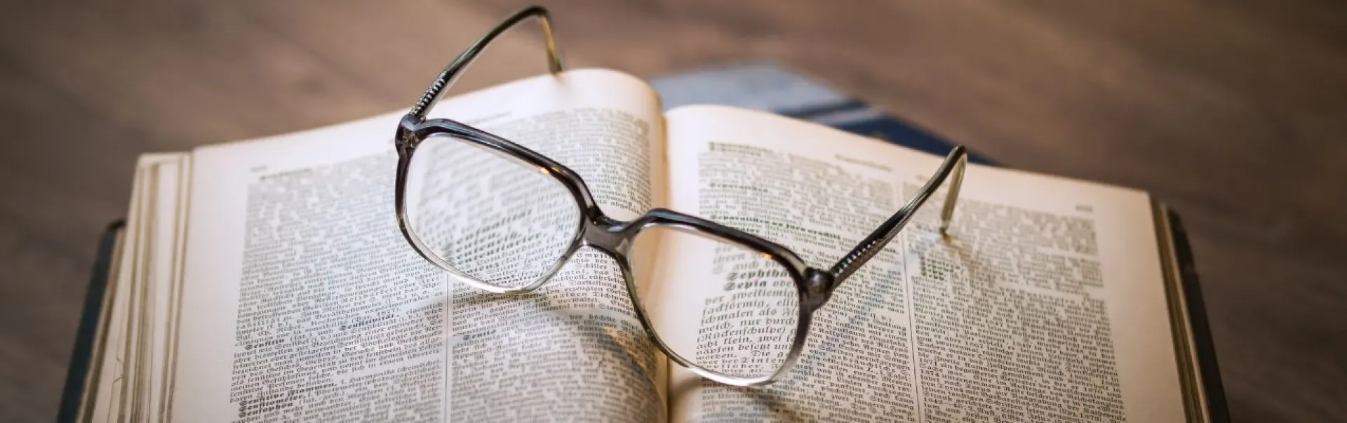 Glasses laid on open book