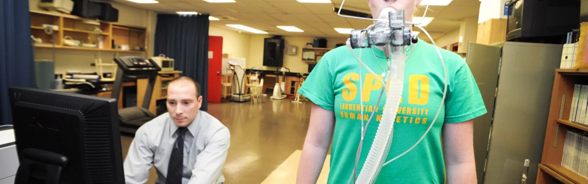 A researcher monitoring the breathing of a subject, who has a respirator mask on.