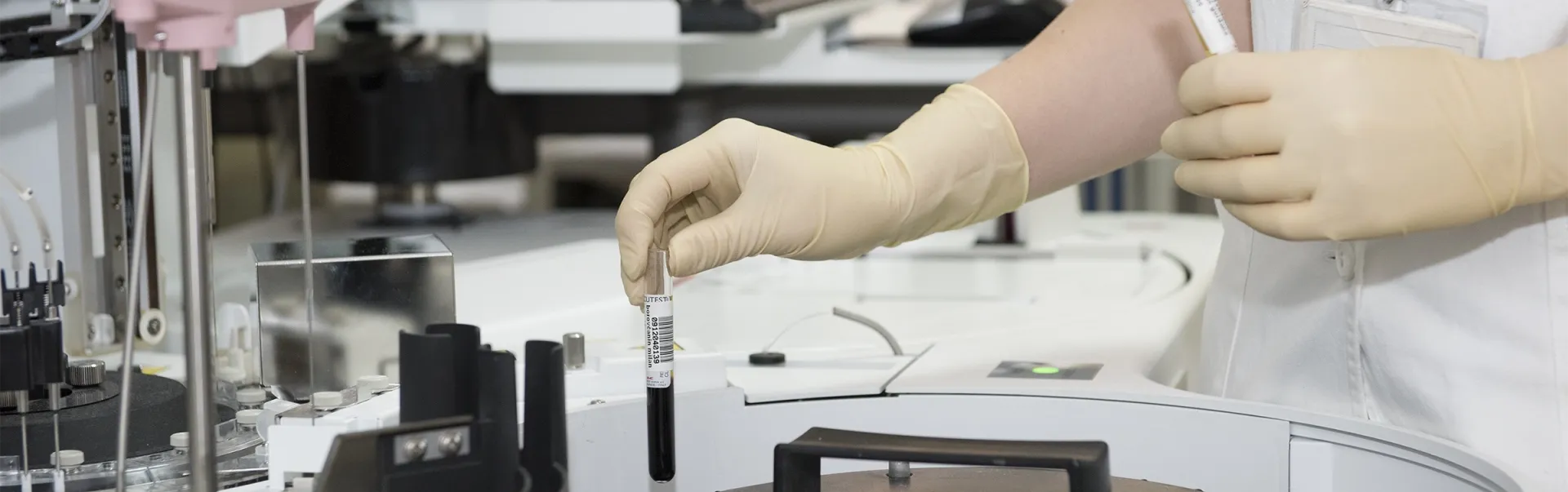 A laboratory worker putting blood samples in a centrifuge.