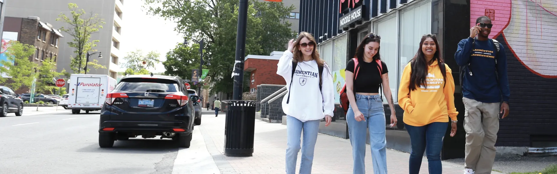 A group of four Laurentian students walking in downtown Sudbury.