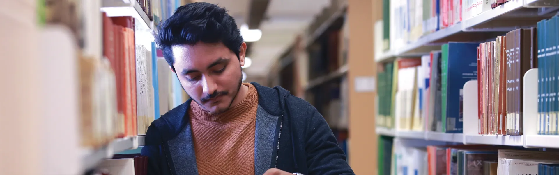 A Laurentian University student reading a book in the J.N. Desmarais library.