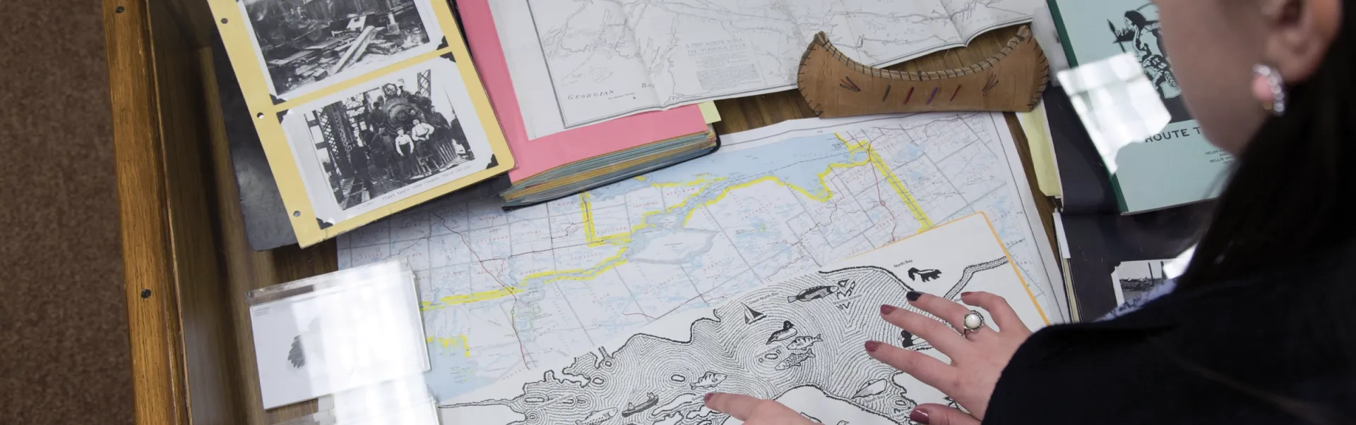 A person looking at a map and historical photos.
