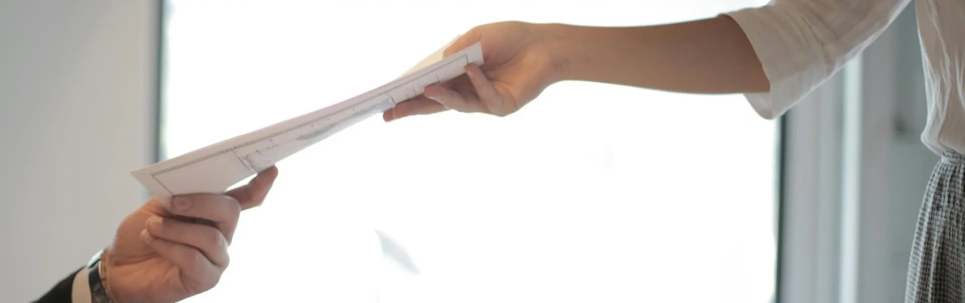 Someone handing documents to someone else