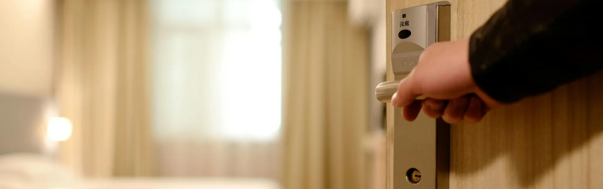 Someone opening the door of a hotel room