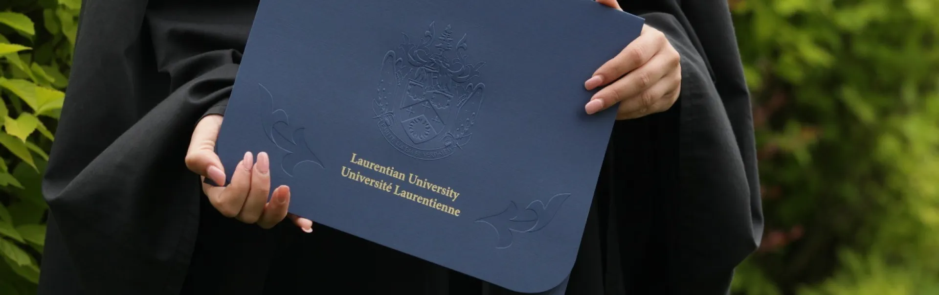 A student holding their degree