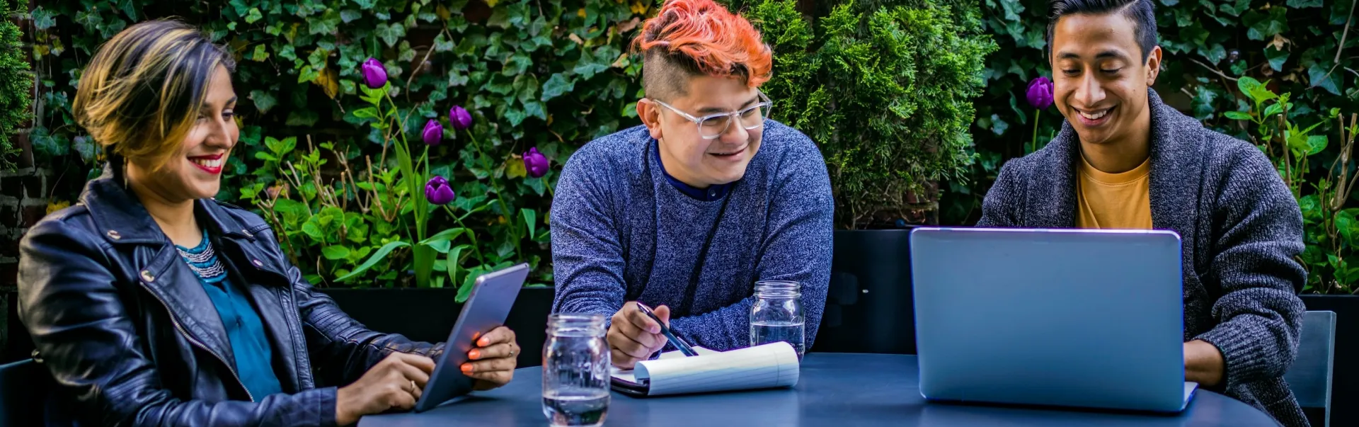Three people sitting at a table with their study material