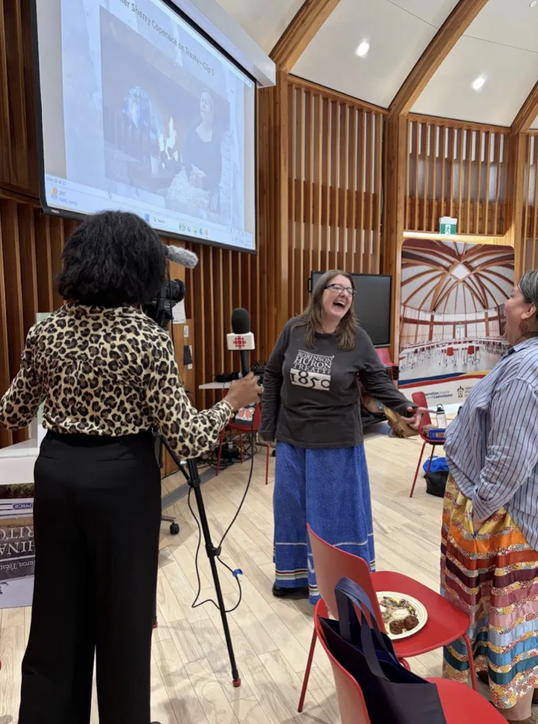Dr. Elizabeth Carlson-Manathara laughing with team member Dawnis Kennedy during an interview with a radio canada reporter inside the Indigenous Sharing and Learning Centre at Laurentian University during the project launch event.