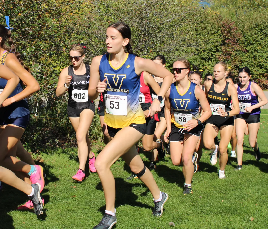 Laurentian Voyageurs runner Charli Borak (center left, wearing bib 53) competes in a pack during a university cross-country race.