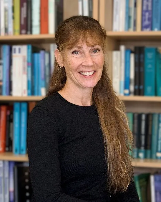 Dr. Jacqueline Litzgus, smiling in front of a bookcase. 